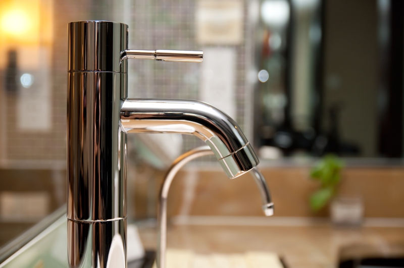 Leaking tap being repaired in Teddington